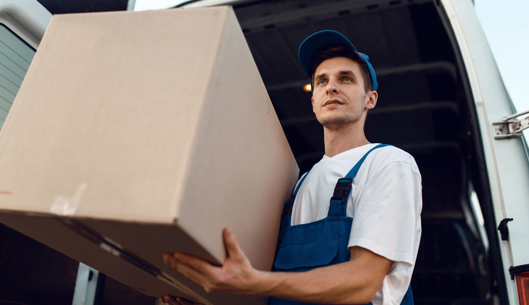 loader in uniform holding box delivery service